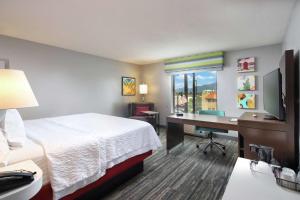 a hotel room with a bed and a desk with a computer at Hampton Inn & Suites Tucson East in Tucson