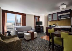 a living room with a couch and a table and a kitchen at Homewood Suites by Hilton Chicago Downtown - Magnificent Mile in Chicago +22 photos