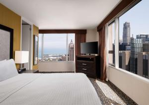 a hotel room with a bed and a large window at Homewood Suites by Hilton Chicago Downtown - Magnificent Mile in Chicago