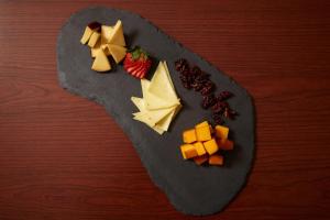 沙倫維爾的住宿－DoubleTree Suites by Hilton Hotel Cincinnati - Blue Ash，木桌上放着一盘奶酪和水果