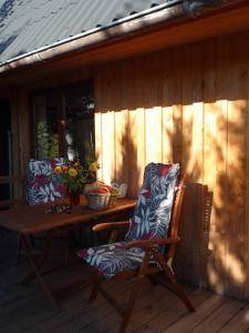 a wooden deck with a table and a chair on it at Ferienwohnung Tischneck in Schramberg