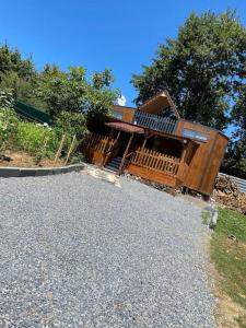 eine Blockhütte mit einer Veranda und einer Einfahrt in der Unterkunft Havuzlu kiralık Tinyhause in Çekme