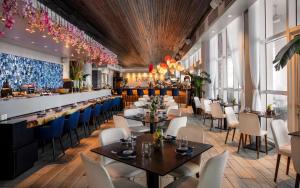 um restaurante com mesas e cadeiras e um bar em Conrad Fort Lauderdale Beach em Fort Lauderdale