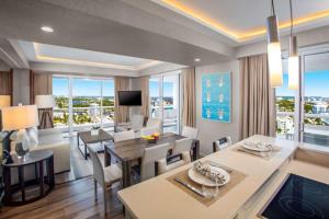 a dining room and living room with a large window at Conrad Fort Lauderdale Beach in Fort Lauderdale
