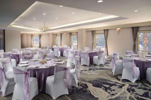 a room filled with tables and chairs with purple bows at Hilton Long Beach Hotel in Long Beach +68 photos