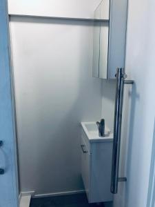 La salle de bains blanche est pourvue d'un lavabo et d'une armoire. dans l'établissement Waikaraka Beach, spacious & very comfortable, à Whangarei Heads