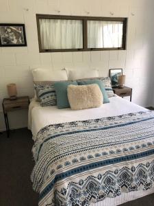 a bedroom with a large bed with blue and white sheets at Waikaraka Beach, spacious & very comfortable in Whangarei Heads