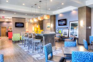 a restaurant with tables and chairs and a bar at Hampton Inn Houston I-10 East, TX in Houston
