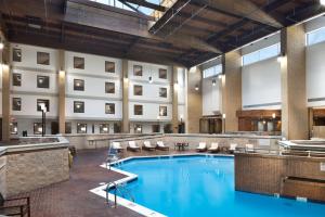 una gran piscina en el vestíbulo del hotel con sillas y un hotel en DoubleTree by Hilton Lawrence en Lawrence