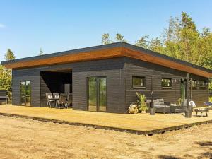 a small cabin with a wooden deck in front at Holiday home Løgstør IX in Løgstør