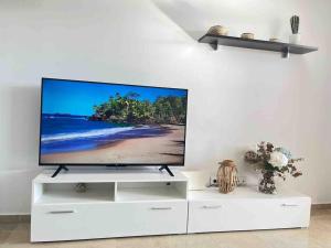 a flat screen tv sitting on a white entertainment center at Feel The Vibe Alcaidesa in San Roque