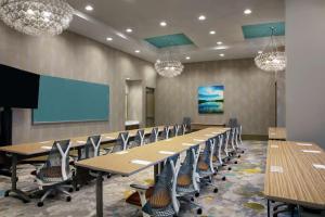 a conference room with tables and chairs and a screen at Hilton Garden Inn Mobile Downtown in Mobile