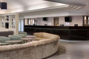 a lobby with a couch and tables and a bar at DoubleTree by Hilton Newbury North in Newbury