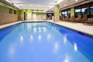 - une grande piscine d'eau bleue dans un bâtiment dans l'établissement Hampton Inn Minneapolis-Roseville,MN, à Roseville