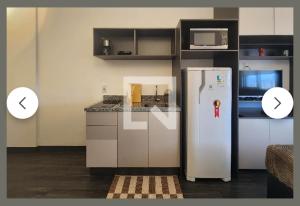 a kitchen with a stainless steel refrigerator and a microwave at Sucesso! Home Studio em São Caetano do Sul in São Caetano do Sul