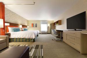 um quarto de hotel com uma cama e uma televisão de ecrã plano em Home2 Suites By Hilton Richland em Richland