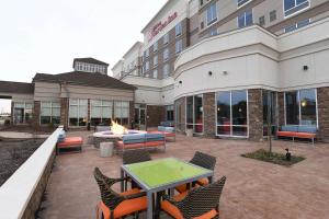 a patio with a table and chairs in front of a building at Hilton Garden Inn Jacksonville in Jacksonville