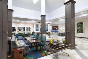 a lobby with blue chairs and tables at Hilton Garden Inn Jacksonville in Jacksonville