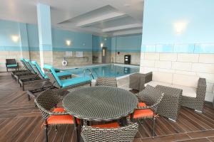 uma piscina com mesa e cadeiras ao lado de uma piscina em Hilton Garden Inn Jacksonville em Jacksonville