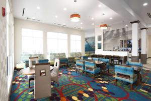 uma sala de jantar com mesas e cadeiras num tapete colorido em Hilton Garden Inn Jacksonville em Jacksonville