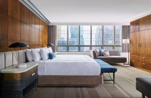 una camera d'albergo con un grande letto e un divano di The Marquette Hotel, Curio Collection by Hilton a Minneapolis