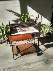 a barbecue cart sitting on a sidewalk with plants at La rana alquiler temporal in Reyes