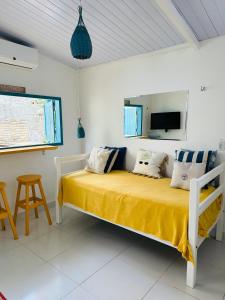 - une chambre avec un lit doté de draps et d'oreillers jaunes dans l'établissement Pipa Beach House Chalés, localizada ao lado do Mirante Sunset Bar, à Pipa
