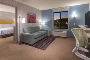 a room with a couch and a bed and a window at Home2 Suites by Hilton Kingman in Kingman