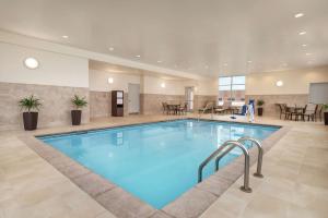 a swimming pool in a hotel lobby with a restaurant at Hampton Inn Brooklyn Park in Brooklyn Park