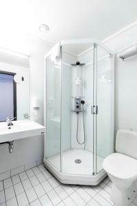 a white bathroom with a shower and a toilet at Park Inn by Radisson Haugesund Airport in Avaldsnes