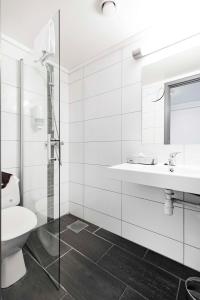 a white bathroom with a sink and a toilet at Park Inn by Radisson Haugesund Airport in Avaldsnes