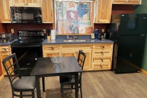 a kitchen with a black table and a black refrigerator at Cedar Mountain -Suite B in Grants Pass