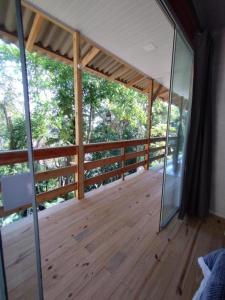 a large room with a wooden deck with glass doors at Castelo de Madeira in Blumenau