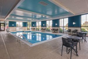 une grande piscine avec des chaises et des tables dans un bâtiment dans l'établissement Hampton Inn Oak Grove Fort Campbell, à Oak Grove