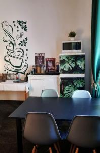 uma sala de jantar com uma mesa preta e cadeiras em Green Cat Rooms em Cracóvia