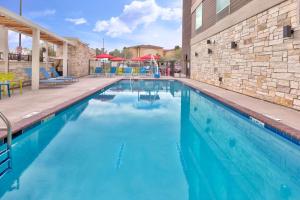 a swimming pool with blue water in front of a building at Home2 Suites By Hilton Tucson Airport, Az in Tucson