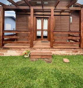 a wooden cabin with a porch in the grass at Suite 391 in Canela