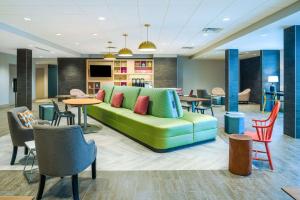 a living room with a couch and tables and chairs at Home2 Suites By Hilton Brunswick in Brunswick