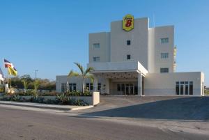 a large white building with a sign on it at Super 8 by Wyndham Manzanillo 