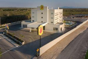 a large white building with a sign in front of it at Super 8 by Wyndham Manzanillo 