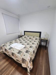 - une chambre avec un lit et une couette dans l'établissement Departamento excelente ubicación, à Godoy Cruz