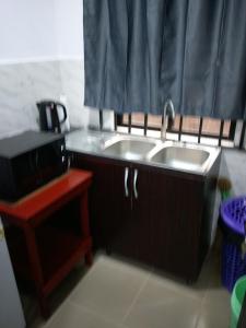 a kitchen with two sinks and a shower curtain at chinaka guest house 24hr light in Lagos