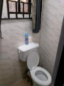 a bathroom with a white toilet in a room at chinaka guest house 24hr light in Lagos