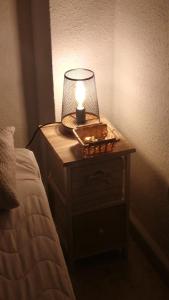 a lamp on a night stand next to a bed at Habitacion en Castilleja de la Cuesta in Castilleja de la Cuesta