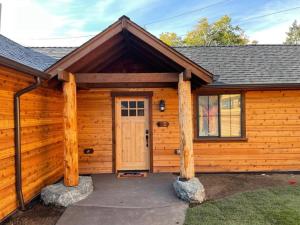 a wooden cabin with a door and two logs at Cedar Mountain Suite D in Grants Pass