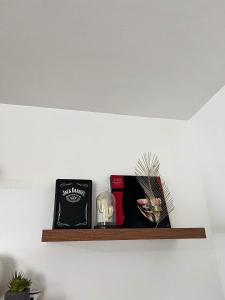a shelf on a wall with books and other items at Cosy House in Bacolod City in Bacolod