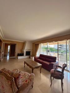 uma sala de estar com um sofá e uma mesa em Spacious house with garden - sea view em Cannes