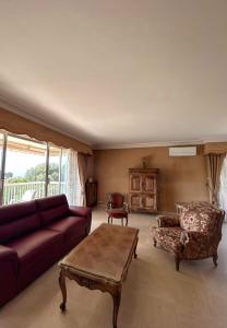 uma sala de estar com um sofá e uma mesa de centro em Spacious house with garden - sea view em Cannes
