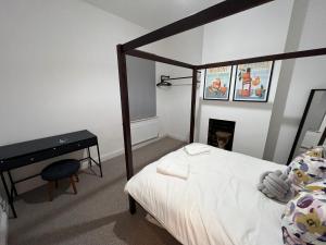 a bedroom with a bed and a desk and a bed sidx sidx sidx at Altrincham Terrace - 2 Bedroom House - Free Parking - Sleeps 6 - Near Tram Stop in Manchester