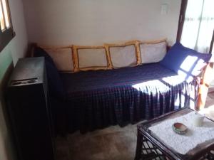 ein kleines Bett in einem Zimmer mit einem Tisch in der Unterkunft La rana alquiler temporal in Reyes